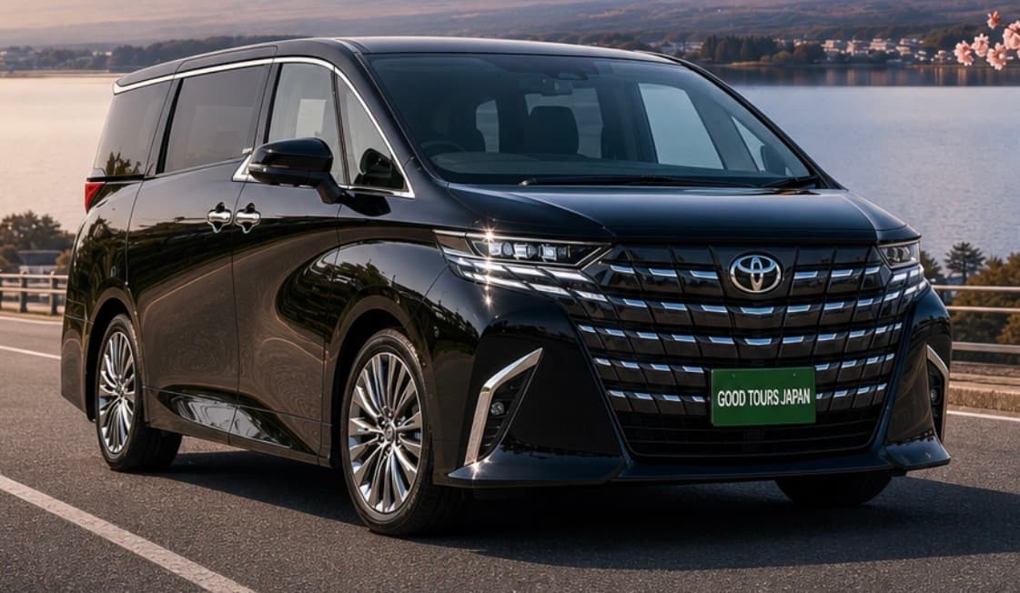 Sleek black Toyota luxury minivan parked on a scenic road overlooking a calm lake.